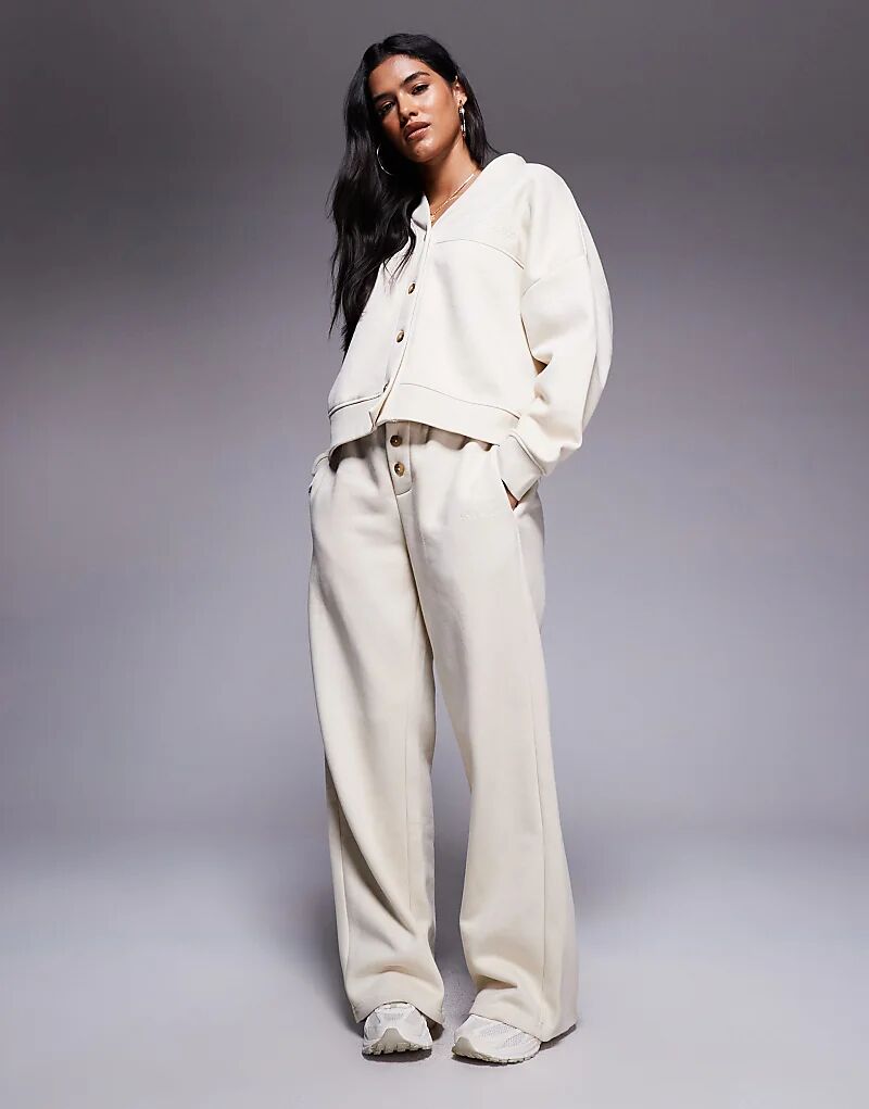 Широкие брюки-джоггеры Kaiia с вышитым логотипом на пуговицах бежевого цвета
Широкие брюки-джоггеры Kaiia с вышитым логотипом на пуговицах бежевого цвета