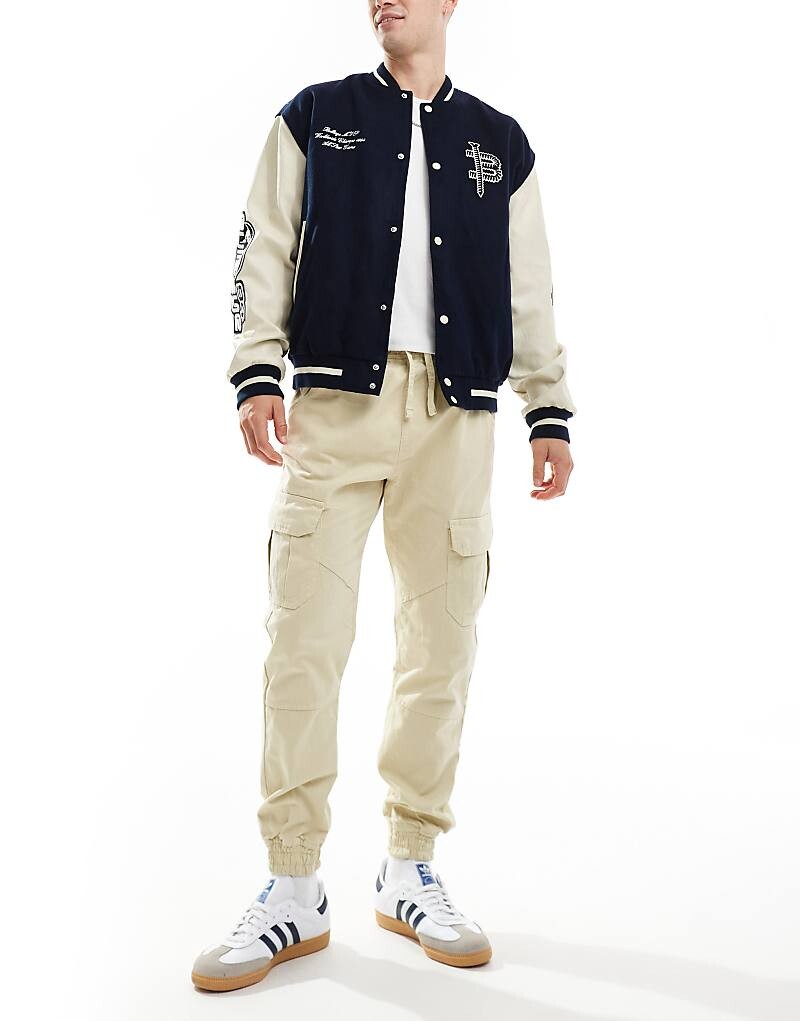 Другое влияние – светлые серо-бежевые брюки в стиле милитари с манжетами по краю
Другое влияние – светлые серо-бежевые брюки в стиле милитари с манжетами по краю