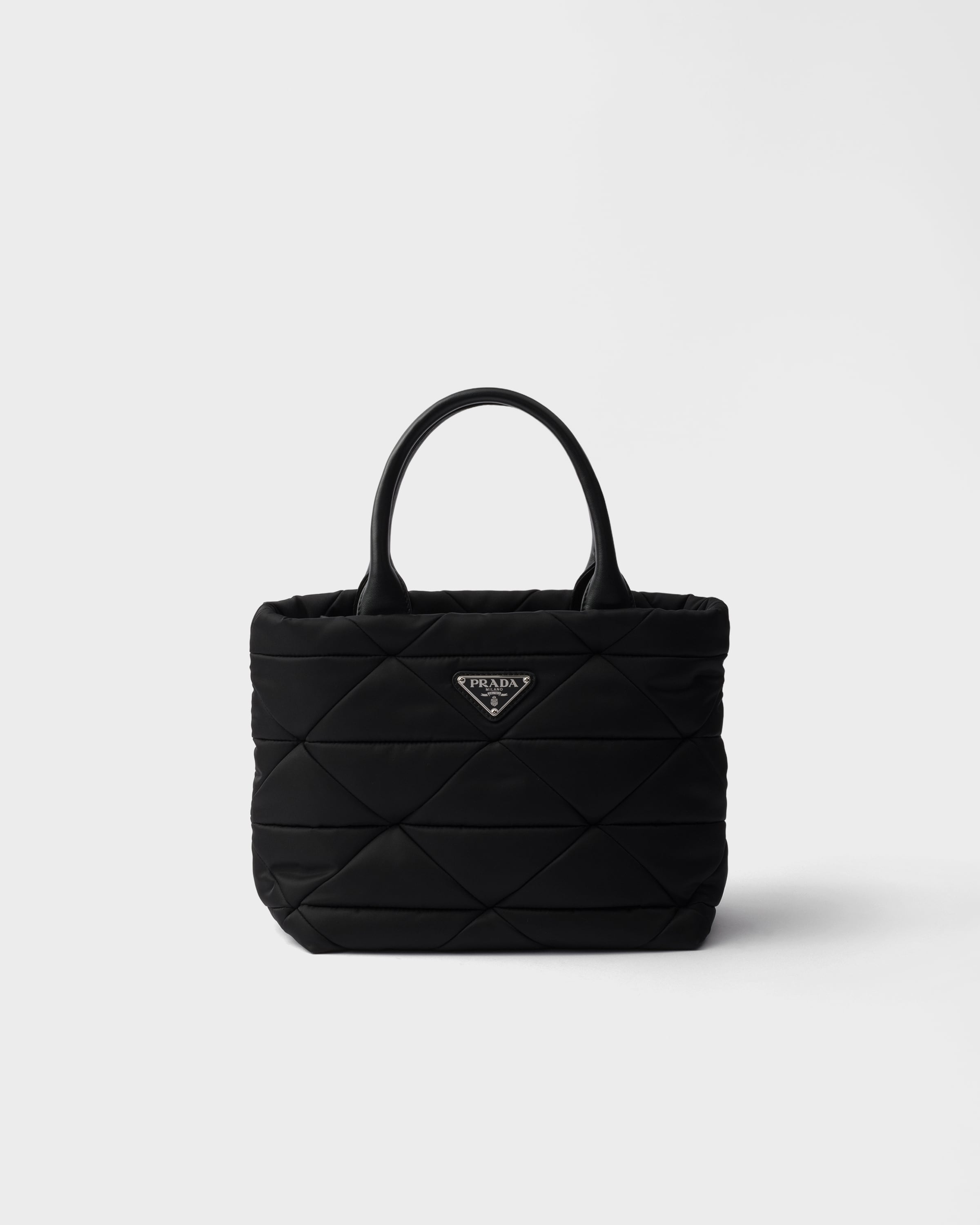 Маленькая стеганая сумка-тоут из переработанного нейлона Prada, черный
Маленькая стеганая сумка-тоут из переработанного нейлона Prada, черный