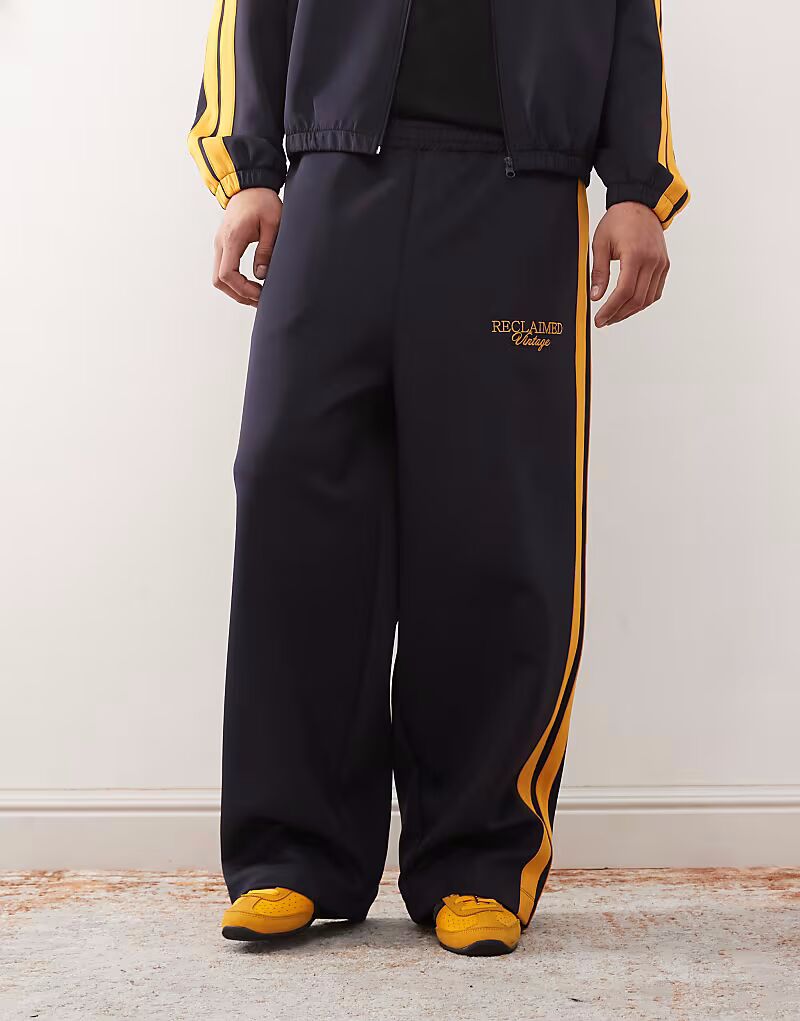 Спортивные брюки с широкими штанинами, темно-синего цвета с полосками по бокам Reclaimed Vintage
Спортивные брюки с широкими штанинами, темно-синего цвета с полосками по бокам Reclaimed Vintage
