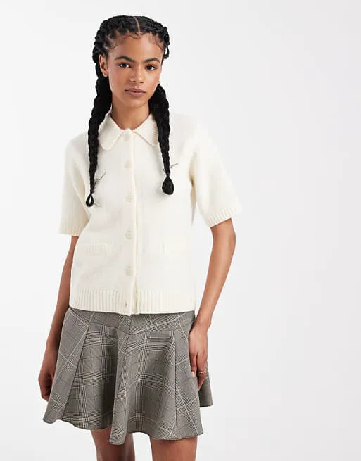 Потертый кардиган с короткими рукавами и воротником цвета экрю
Потертый кардиган с короткими рукавами и воротником цвета экрю