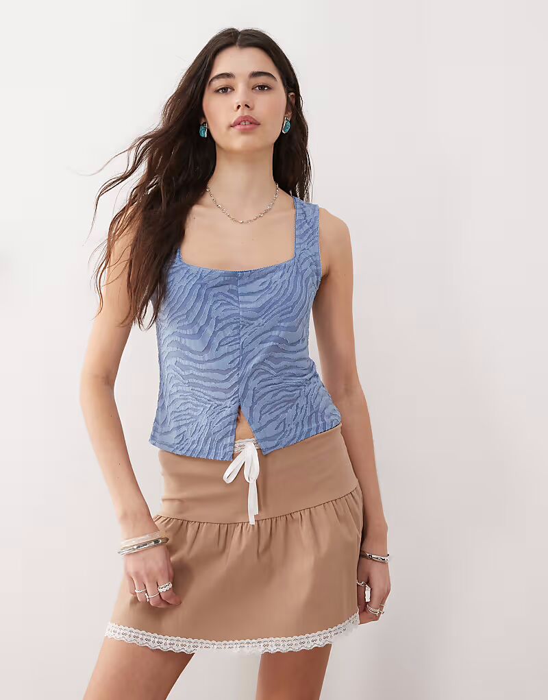 Топ Reclaimed Vintage с разрезом спереди, с синим флокированным принтом зебры 
Топ Reclaimed Vintage с разрезом спереди, с синим флокированным принтом зебры