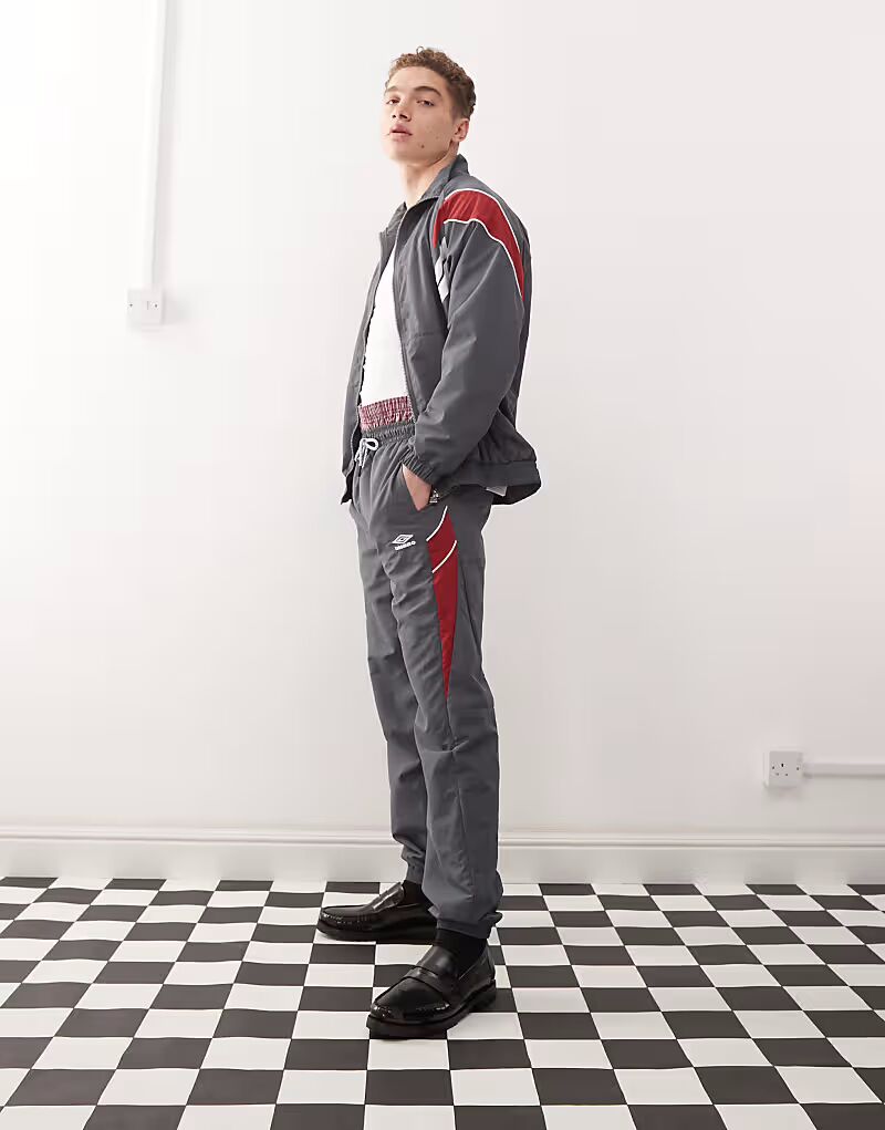 Свободные спортивные брюки серого цвета с несколькими принтами Umbro
Свободные спортивные брюки серого цвета с несколькими принтами Umbro