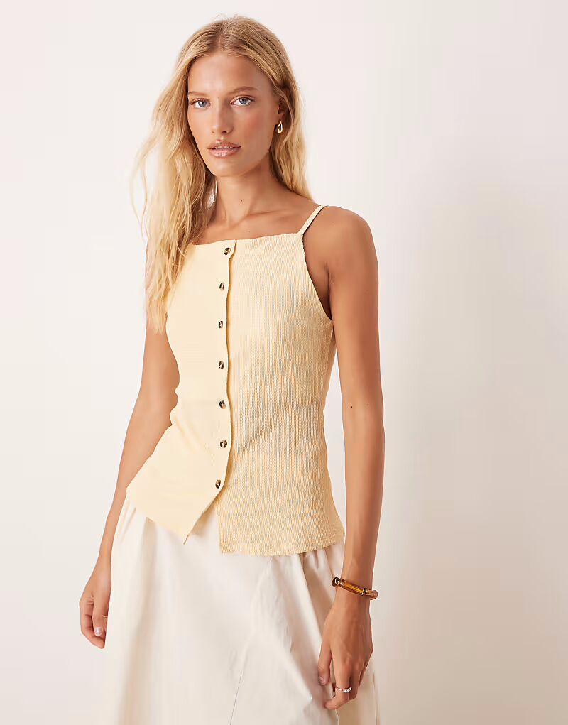 Текстурированный топ на пуговицах с бретельками в цвете пахты и желтого цвета Asos Design
Текстурированный топ на пуговицах с бретельками в цвете пахты и желтого цвета Asos Design