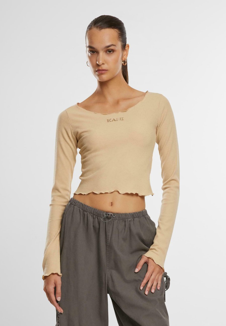 Топ Karl Kani Long sleeved top, Sand
Топ Karl Kani Long sleeved top, Sand
