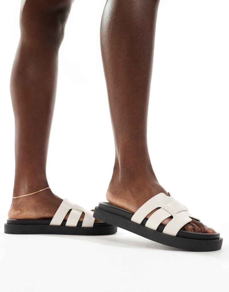 Schuh – Timmy – Сандалии на плоской подошве с узором из крокодиловой кожи цвета экрю
Schuh – Timmy – Сандалии на плоской подошве с узором из крокодиловой кожи цвета экрю