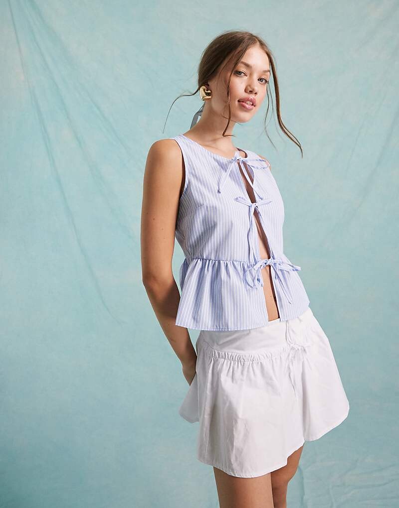 Синий топ без рукавов Miss Selfridge из поплина с завязкой спереди и полосками
Синий топ без рукавов Miss Selfridge из поплина с завязкой спереди и полосками