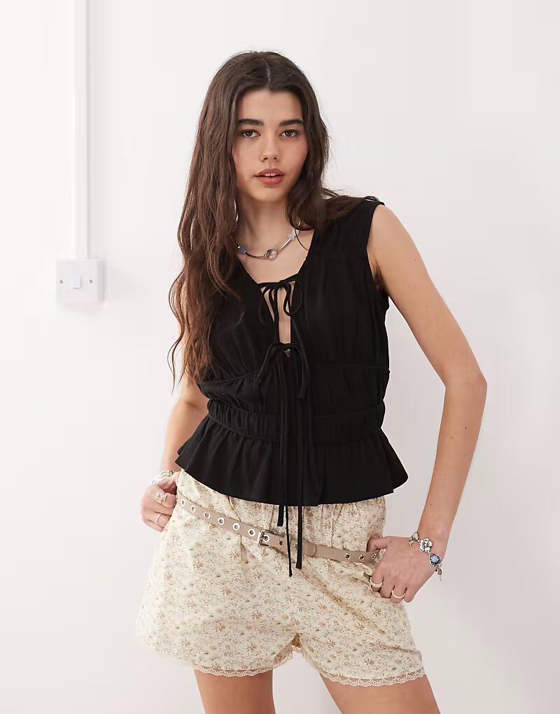 Топ Reclaimed Vintage из льняной смеси черного цвета с завязками спереди и сборками
Топ Reclaimed Vintage из льняной смеси черного цвета с завязками спереди и сборками