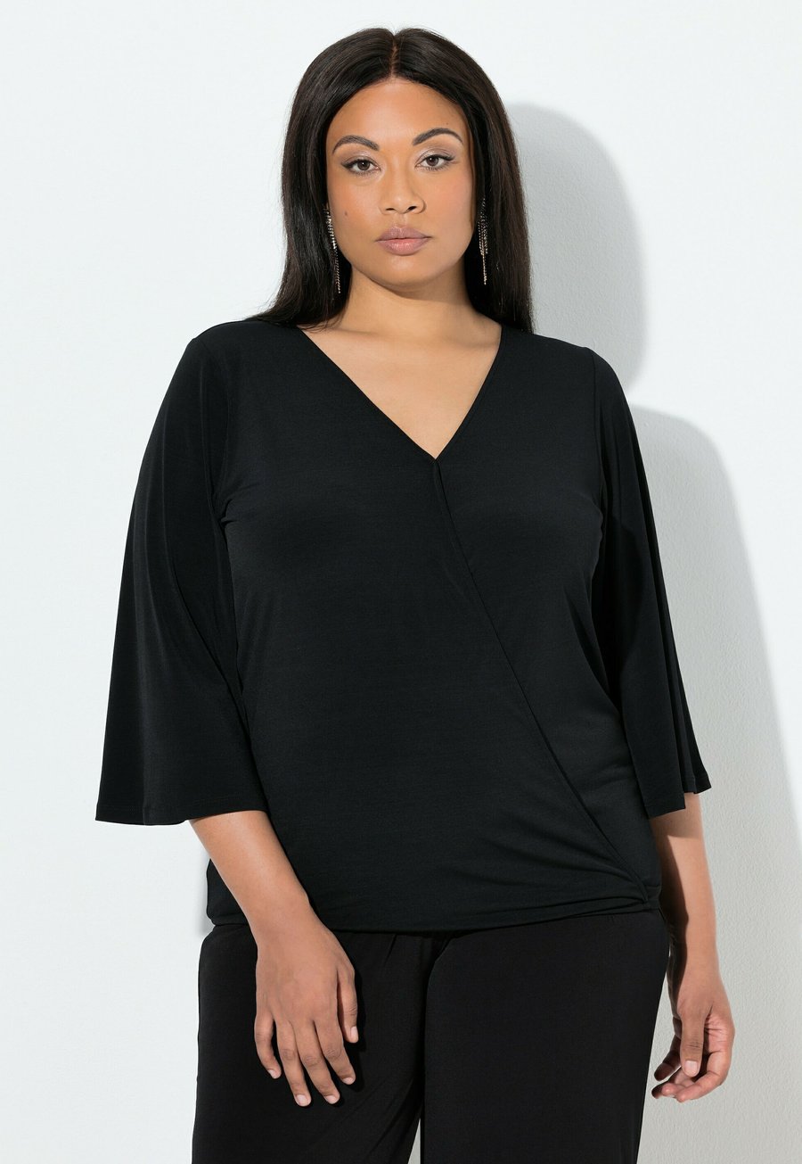 Топ Ulla Popken WICKELOPTIK V-AUSSCHNITT 3/4-GLOCKENÄRMEL, Black
Топ Ulla Popken WICKELOPTIK V-AUSSCHNITT 3/4-GLOCKENÄRMEL, Black