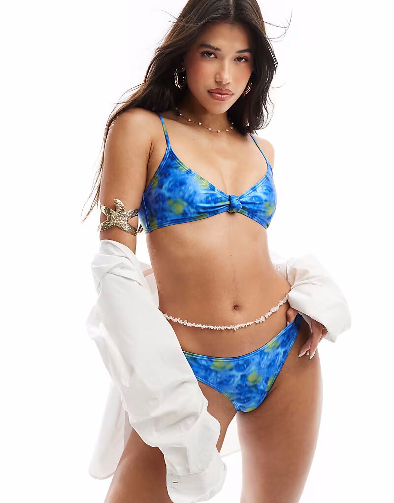 Верх бикини South Beach с узлом спереди и цветочным абстрактным принтом синего цвета
Верх бикини South Beach с узлом спереди и цветочным абстрактным принтом синего цвета