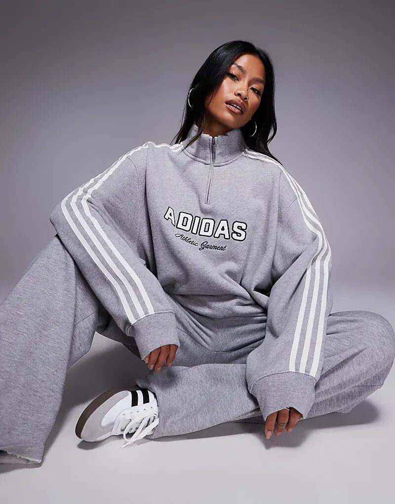 Толстовка Adidas Originals с застежкой-молнией 1/4 серого цвета с графикой спереди
Толстовка Adidas Originals с застежкой-молнией 1/4 серого цвета с графикой спереди