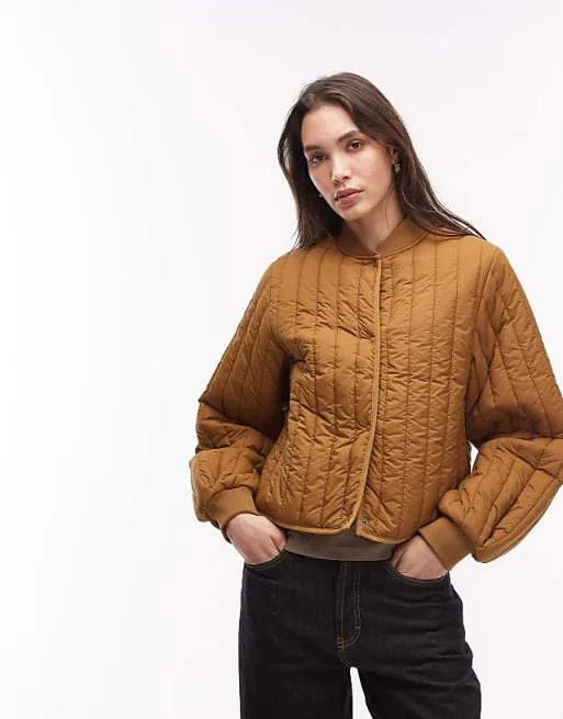 Золотисто-коричневый водоотталкивающий стеганый бомбер Rains 21760 Banja
Золотисто-коричневый водоотталкивающий стеганый бомбер Rains 21760 Banja