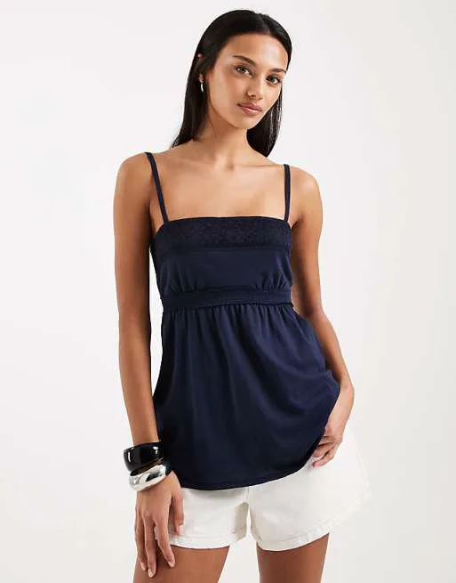 Темно-синяя майка в стиле бэби-долл Hollister с кружевной отделкой
Темно-синяя майка в стиле бэби-долл Hollister с кружевной отделкой