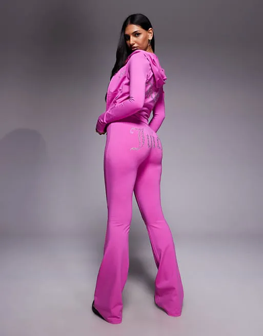 Ярко-розовые велюровые джоггеры с завязками и логотипом Juicy Couture
Ярко-розовые велюровые джоггеры с завязками и логотипом Juicy Couture