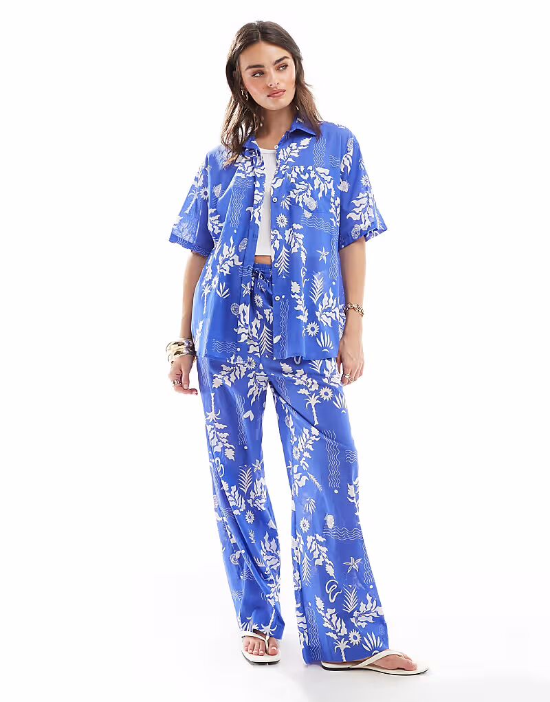 Пляжная рубашка свободного кроя с принтом от Iisla & Bird, синяя
Пляжная рубашка свободного кроя с принтом от Iisla & Bird, синяя