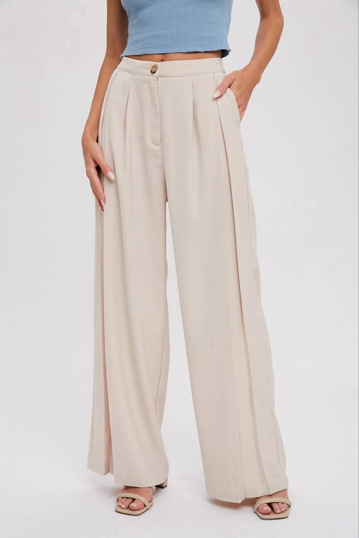 Бежевые брюки с защипами и широкими штанинами BluIvy
Бежевые брюки с защипами и широкими штанинами BluIvy