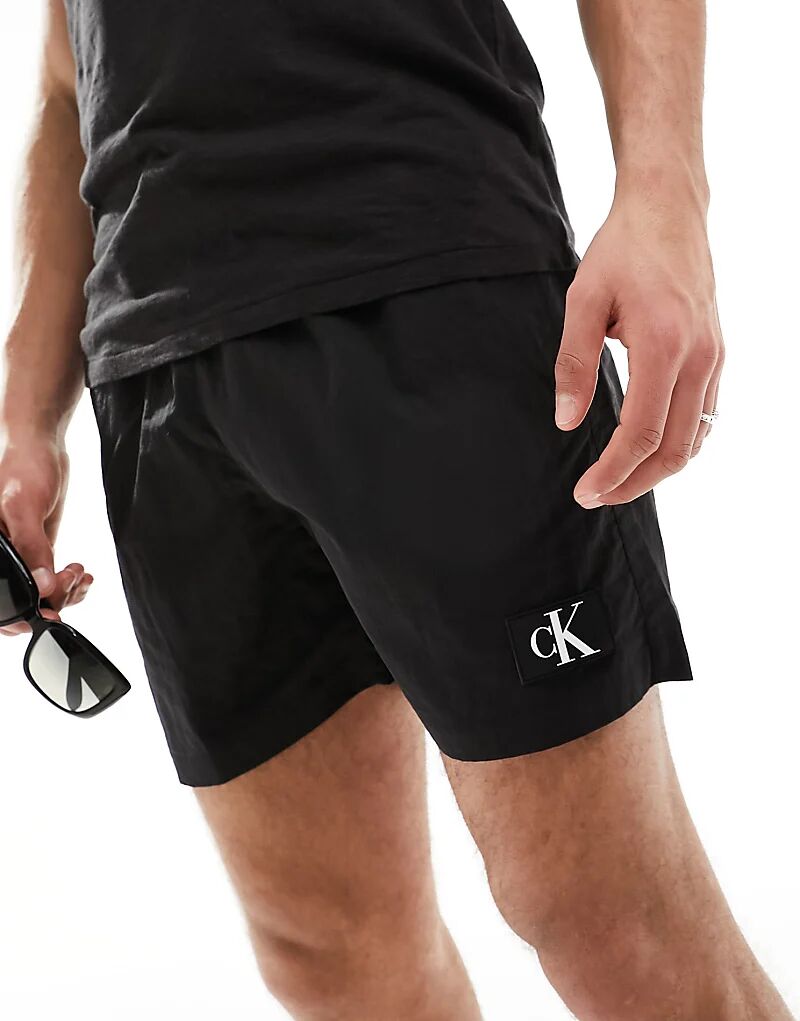 Шорты для плавания из нейлона с монограммой и завязками черного цвета Calvin Klein
Шорты для плавания из нейлона с монограммой и завязками черного цвета Calvin Klein