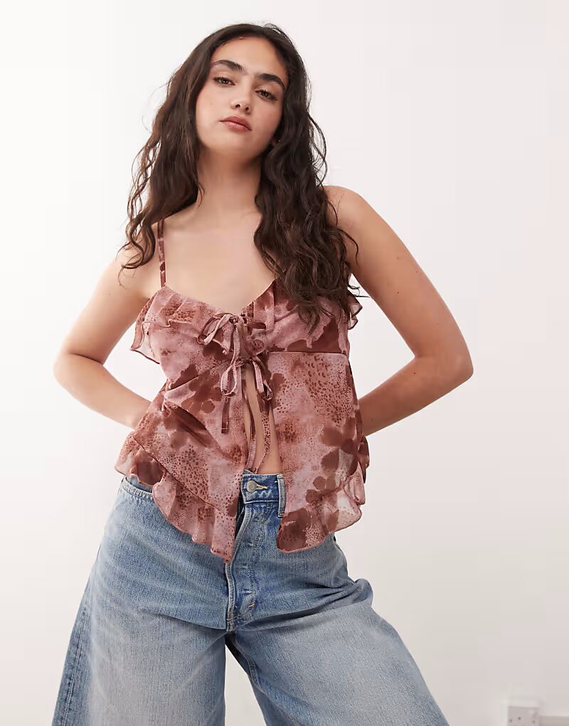 Топ в стиле бохо Reclaimed Vintage с завязками спереди и оборками, с розовым цветочным принтом
Топ в стиле бохо Reclaimed Vintage с завязками спереди и оборками, с розовым цветочным принтом