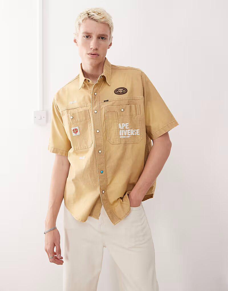 Рубашка Aape by A Bathing Ape с короткими рукавами бежевого цвета с вышивкой на спине AAPE BY A BATHING APE
Рубашка Aape by A Bathing Ape с короткими рукавами бежевого цвета с вышивкой на спине AAPE BY A BATHING APE