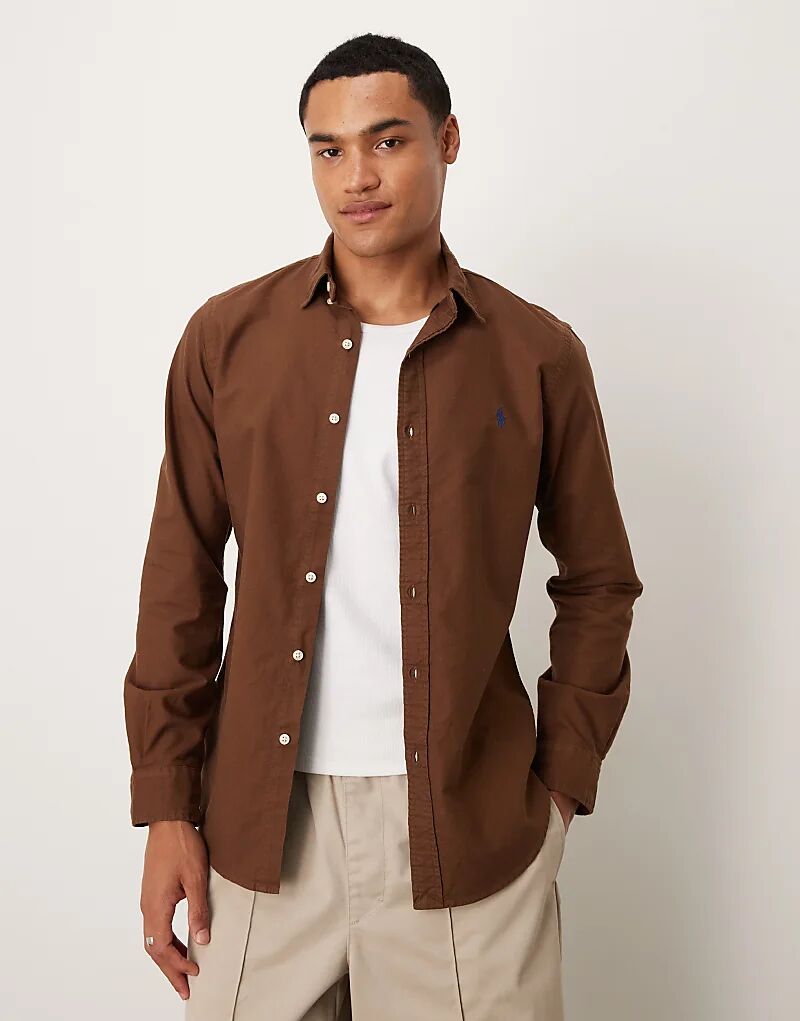 Рубашка оксфорд с логотипом Polo Ralph Lauren, облегающая, окрашенная в коричневый цвет
Рубашка оксфорд с логотипом Polo Ralph Lauren, облегающая, окрашенная в коричневый цвет
