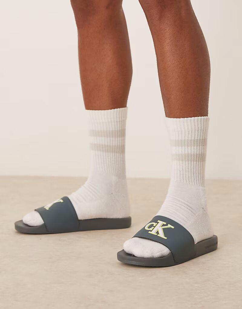 Шлепанцы с большим логотипом Calvin Klein Jeans в цвете сине-зеленый и белый
Шлепанцы с большим логотипом Calvin Klein Jeans в цвете сине-зеленый и белый