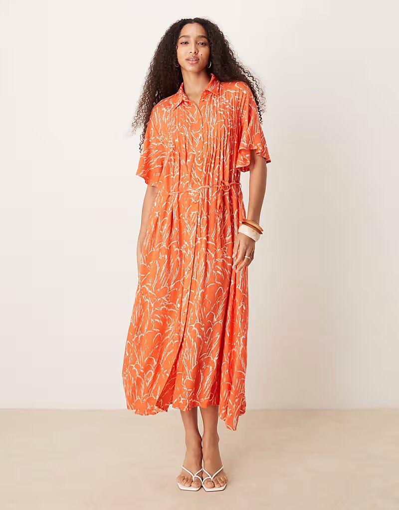 Платье YAS с поясом, застежкой на пуговицы спереди, расклешенными рукавами и оранжевым цветочным принтом 
Платье YAS с поясом, застежкой на пуговицы спереди, расклешенными рукавами и оранжевым цветочным принтом