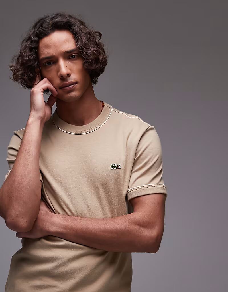 

Футболка Lacoste белого цвета с темно-синей отделкой и манжетами рукавов