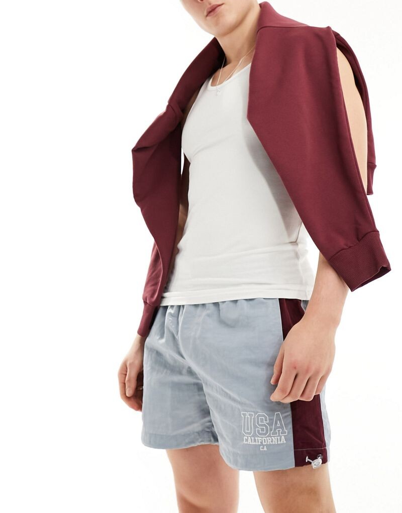 

Синие широкие нейлоновые шорты с полосками по бокам и вышивкой ASOS DESIGN