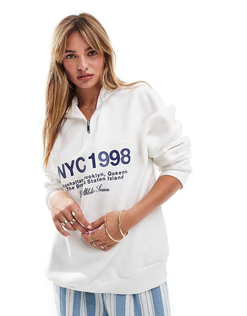 

Bershka = Толстовка цвета экрю с принтом NY = и молнией на шее>