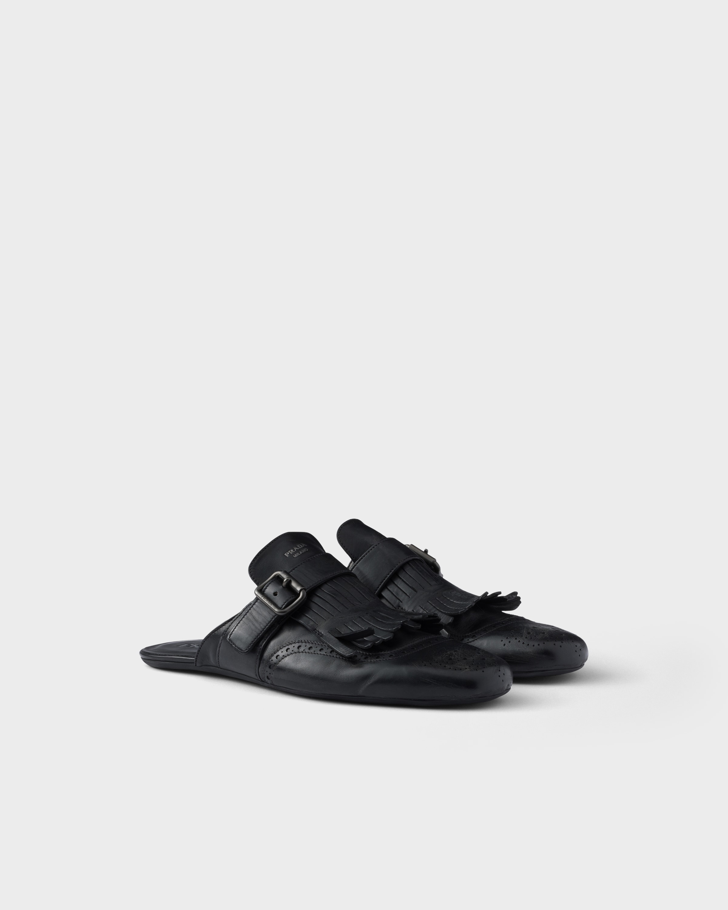 

Шлепанцы Shuffle из состаренной кожи с пряжкой и бахромой Prada, черный