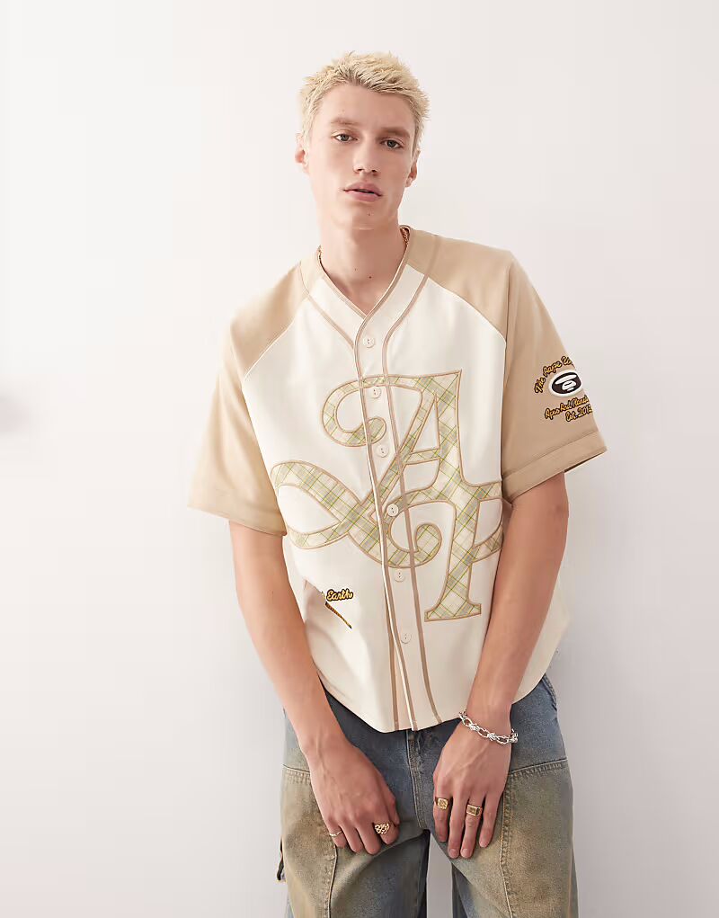 

Футболка бейсбольная студенческая Aape by A Bathing Ape бежевого цвета AAPE BY A BATHING APE