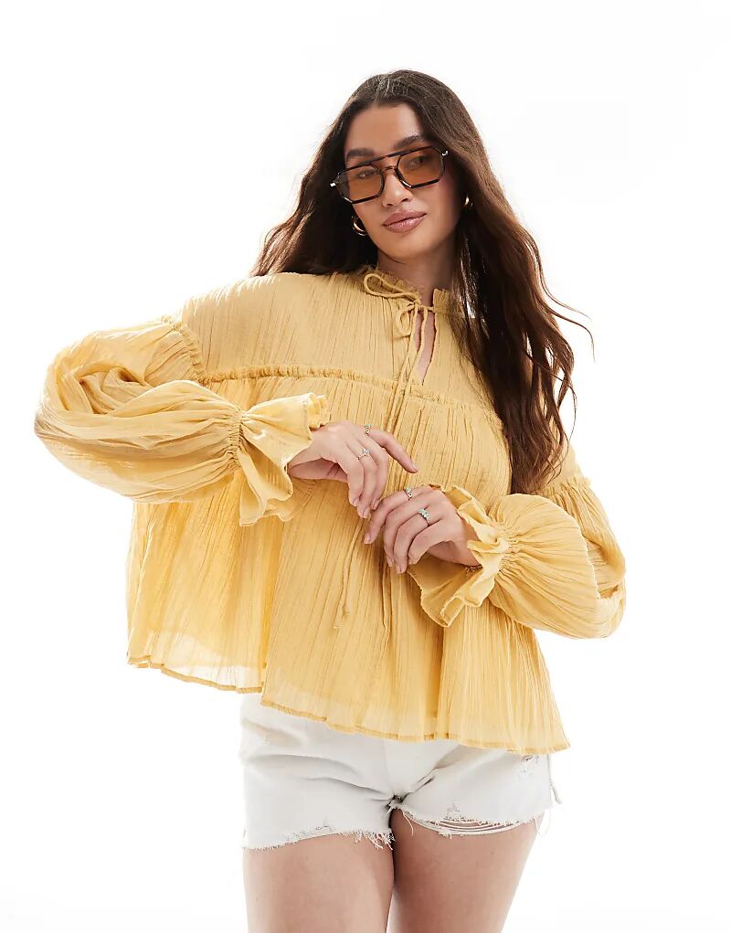

Топ ASOS DESIGN с длинными рукавами, завязкой на вороте, оборками и жатым узором, горчичного цвета
