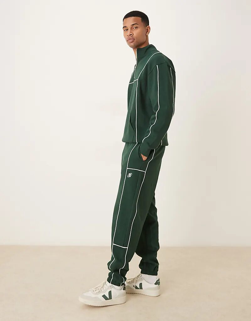 

Спортивные брюки свободного кроя ASOS DESIGN с окантовкой и принтом зеленого цвета — часть комплекта