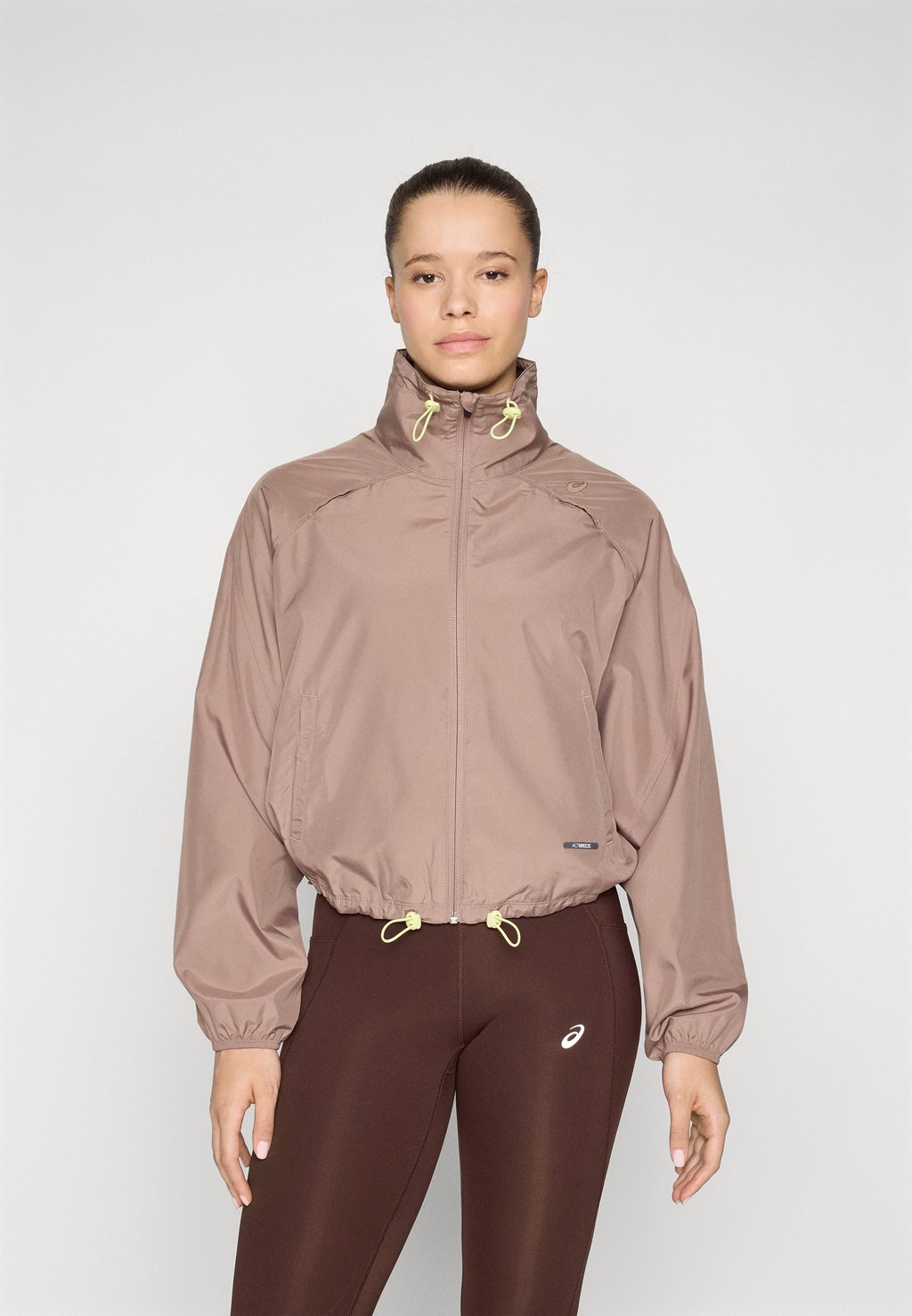 

Куртка для бега NAGINO SHORT JACKET - Windbreaker ASICS, серо-коричневый