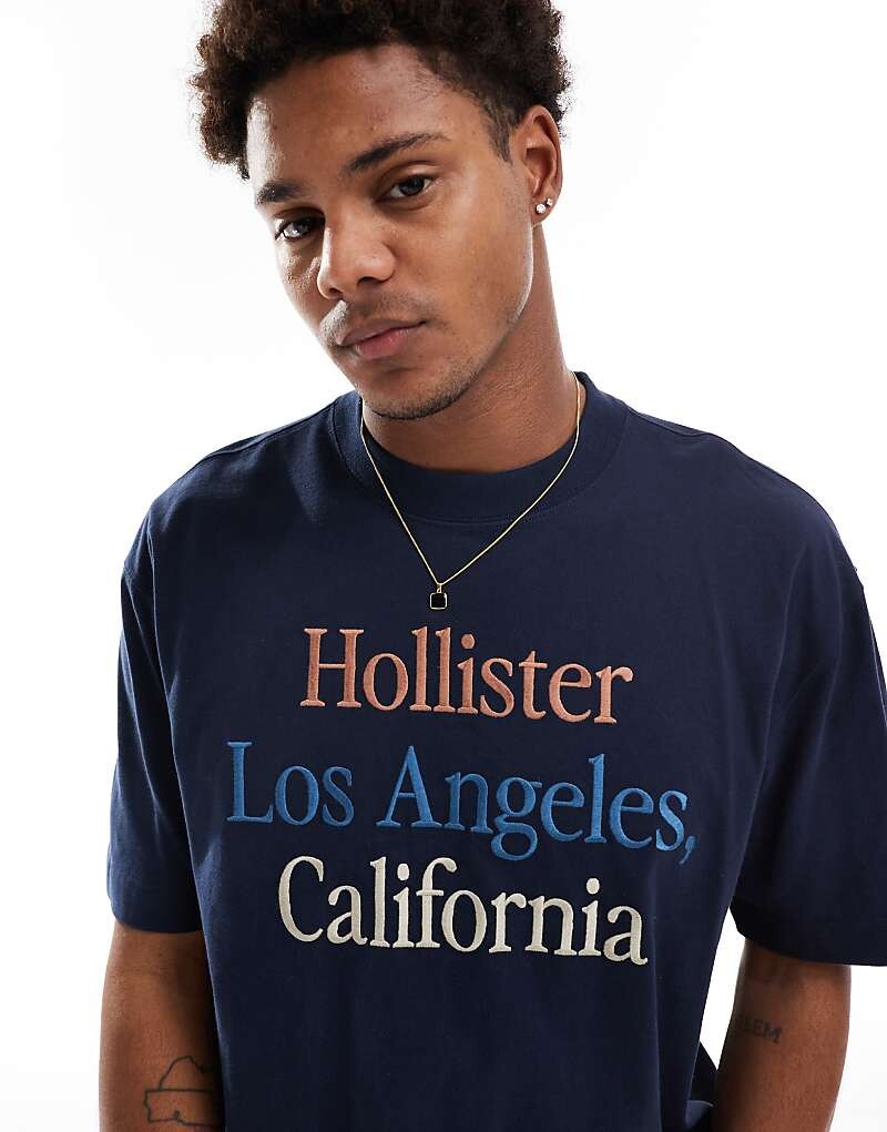 

Hollister – темно-синяя толстая футболка свободного кроя с ярким логотипом