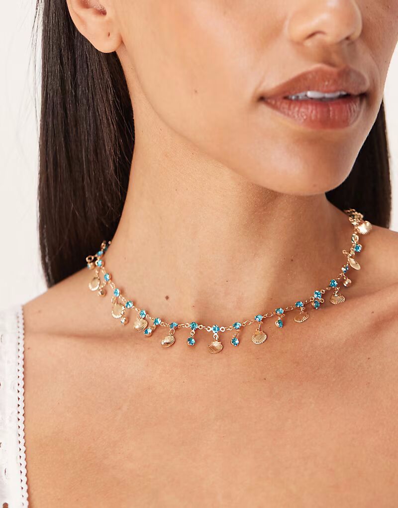 

Ожерелье с миниатюрной ракушкой золотистого оттенка и синими искусственными кристаллами Asos Design