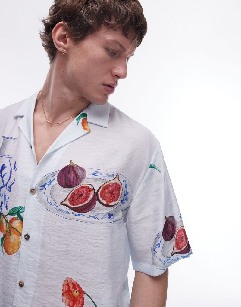 

Topman — голубая рубашка свободного кроя с короткими рукавами и нарисованным от руки принтом