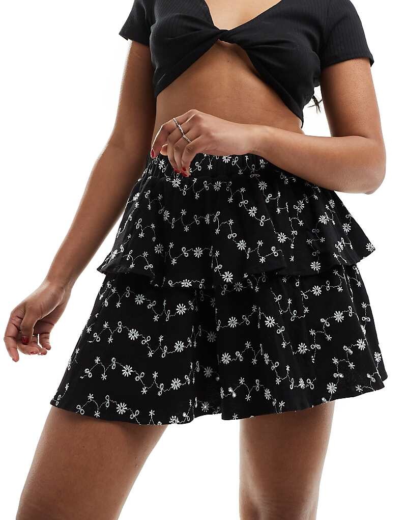 

ASOS DESIGN – Короткая многоярусная юбка черного цвета с рюшами и вышивкой на люверсах