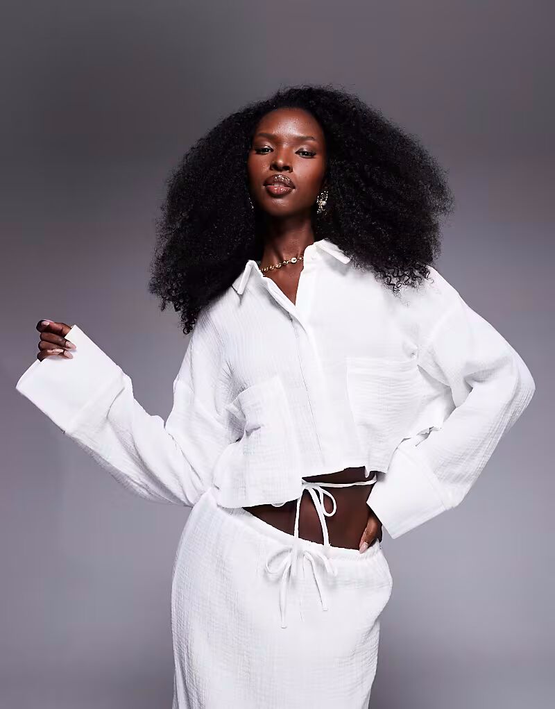 

Эксклюзивная укороченная рубашка свободного кроя из фактурного хлопка с завязками сзади, белого цвета Kaiia