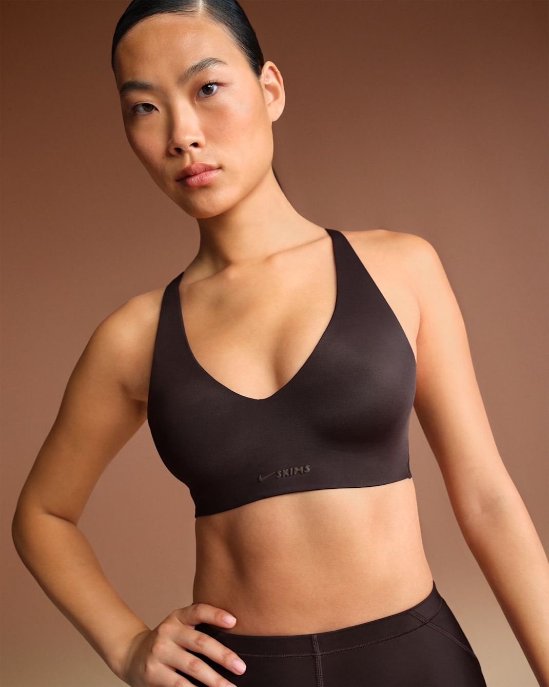 

Спортивный топ NikeSKIMS Shine Women's V-Neck, темно-коричневый