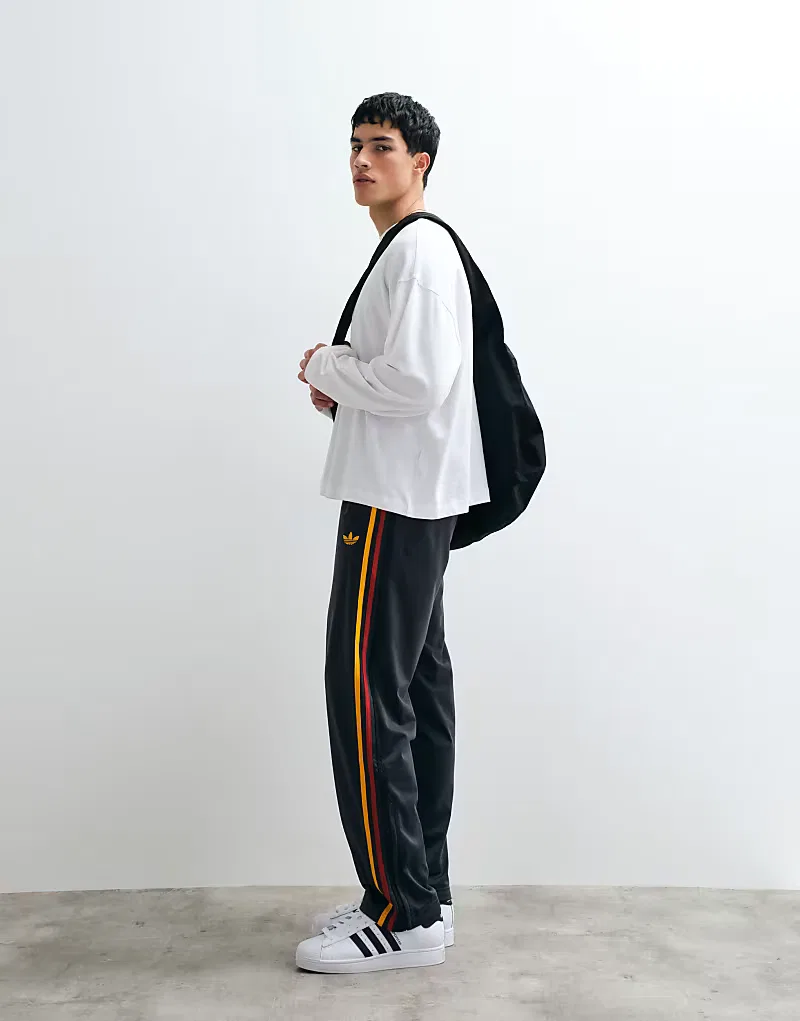 Спортивные брюки Adidas Originals Firebird в черно-золотом цвете