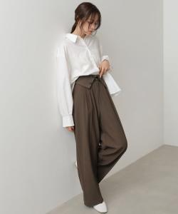 Широкие брюки с откидной лямкой на поясе и пуговицами.