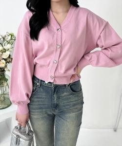 Вязаный кардиган с V-образным вырезом и пуговицами в форме сердца, выполненный из трикотажа.