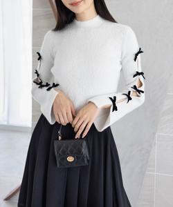 Вязаный топ из люрекса с перьями и лентой на рукаве.