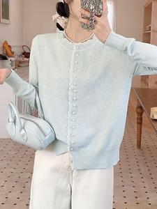 Женский вязаный топ с отделкой из пуговиц, напоминающих жемчуг.