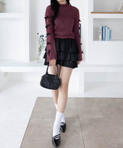 Вязаный топ из люрекса с перьями и лентой на рукаве.