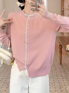 Женский вязаный топ с отделкой из пуговиц, напоминающих жемчуг.