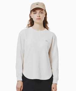 Закругленный низ, воротник-стойка в тон, футболка с длинными рукавами в вафельную полоску.