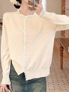 Женский вязаный топ с отделкой из пуговиц, напоминающих жемчуг.