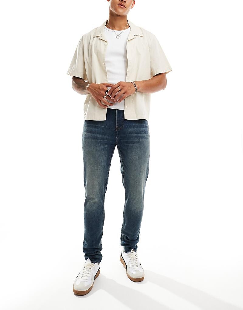 

ASOS DESIGN – темно-синие джинсы скинни с желтым эффектом размытия